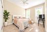 2nd. Floor: Light-filled room featuring wood-finish flooring, dual windows with wide white trim, a ceiling fan, and a radiator