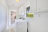 Indoor laundry room leading to workshop in garage