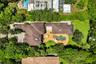 Expansive property featuring a multi-gabled roofline, a large freeform swimming pool with a surrounding paved deck, and a spacious lawn area