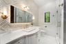 Custom vanity with a curved countertop, integrated sink, and gold-finish fixtures