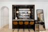 Built-in wet bar with a dark wood finish and stone countertop, illuminated by two pendant light fixtures