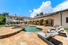 Resort-style backyard featuring a freeform swimming pool, integrated spa, and expansive paver patio