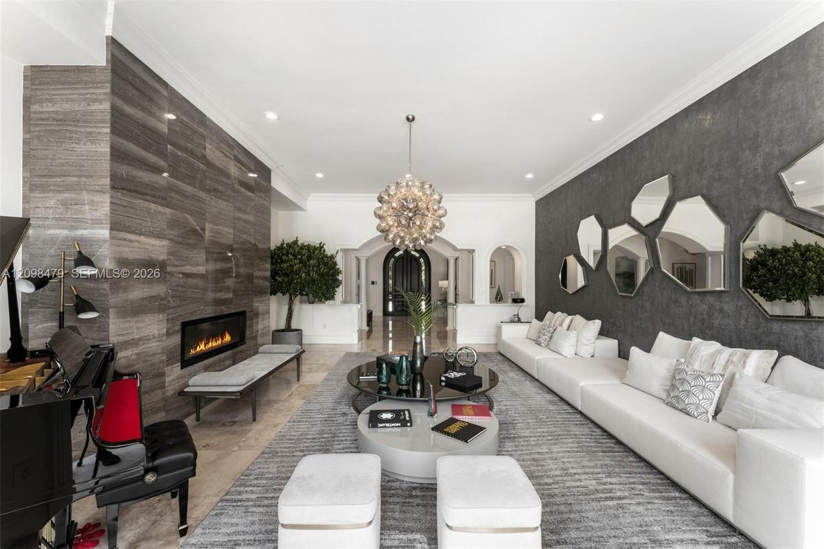 Recessed lighting illuminates a long wall featuring a linear fireplace and stone-finish paneling