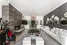 Recessed lighting illuminates a long wall featuring a linear fireplace and stone-finish paneling