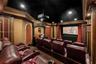 Dedicated home theater featuring a large projection screen, integrated projector, and recessed lighting