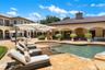 Expansive outdoor living area featuring a freeform swimming pool, integrated spa, and extensive paver patio