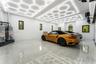 Spacious garage with polished concrete flooring, integrated hexagonal ceiling lighting, multiple windows, and a roll-up garage door