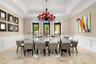 Recessed ceiling with layered crown molding, arched windows, wainscoting, and large format tile flooring