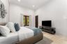 Recessed ceiling lighting, crown molding, double French doors, large format stone flooring, and a built-in media console