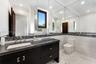 Dark wood-finish vanity with a rectangular undermount sink and brushed nickel fixtures