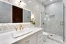 White vanity with gold hardware, a rectangular vessel sink, and gold-finish faucet
