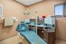 Examination room featuring custom built-in cabinetry, a stainless steel sink, tile flooring, and a drop ceiling