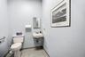 Wall-mounted porcelain sink with dual-handle faucet, rectangular medicine cabinet, and tiled flooring