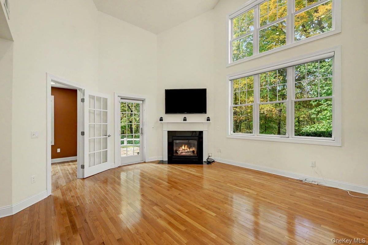 Bright and sunfilled living room featuring double windows with custom automatic window treatments.