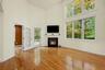 Bright and sunfilled living room featuring double windows with custom automatic window treatments.