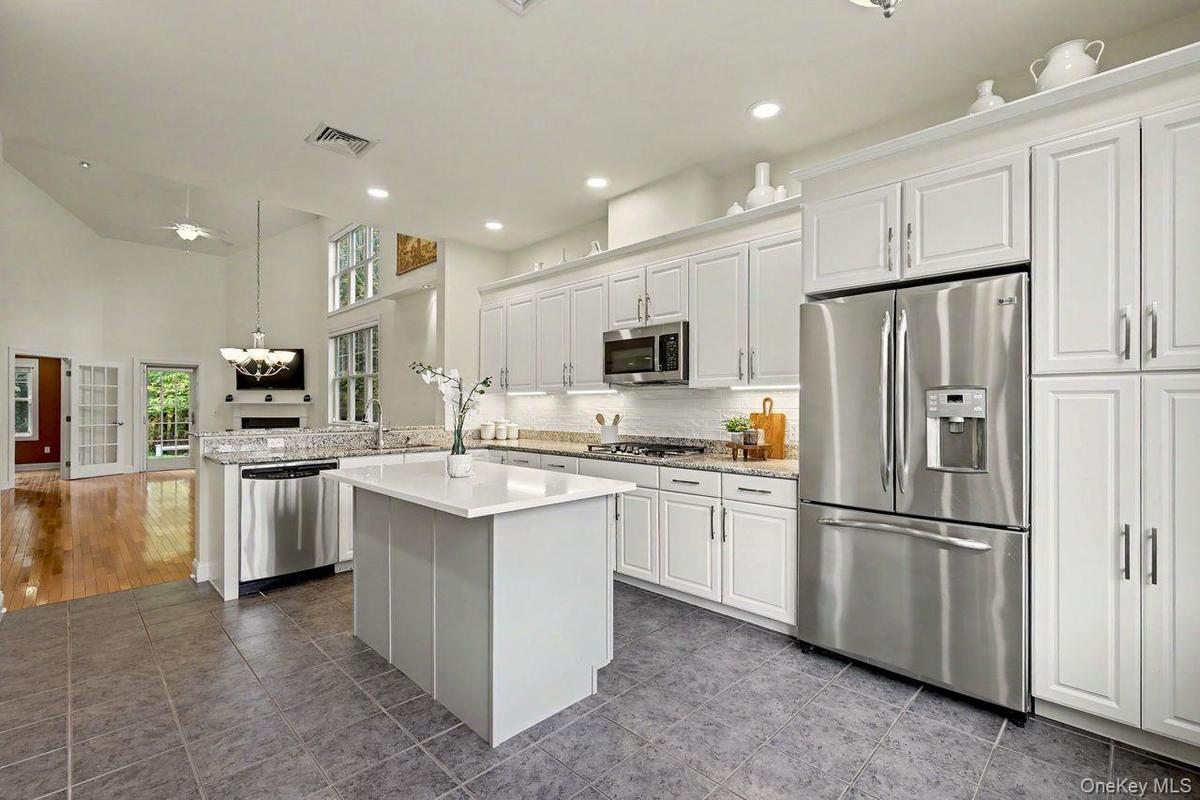 Large eat-in kitchen with center island, stainless steel appliances and under cabinet lighting.