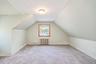 2nd floor bedroom featuring, wall-to-wall carpeting, a central window with wood trim, and a classic metal radiator