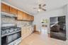 Kitchen featuring wood cabinetry, tile backsplash, stainless steel gas range and dishwasher.