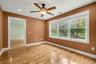 First floor den between primary suite and living space with ceiling fan and hi-hats.