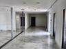 Large-format stone-look tile flooring with grey veining, recessed ceiling lighting, and structural support columns