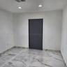Large-format stone-look floor tiling with matching wall trim, recessed ceiling lighting, and a single-panel interior door