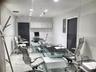 Polished stone flooring, recessed ceiling lighting, wall-mounted upper cabinetry, and glass-partitioned wall enclosure