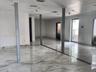 Polished stone-finish tile flooring, recessed ceiling lighting, and structural support columns