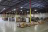 Industrial warehouse facility featuring high-clearance exposed steel truss ceilings, polished concrete flooring, extensive overhead LED lighting, and 