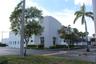 Commercial industrial building featuring a concrete exterior, multi-pane window configuration, and dedicated asphalt parking area