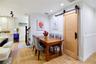 Dining area with stylish sliding barn door opening to an additional pantry and storage room.