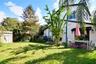 Expansive backyard with mature palms, green lawn, and views of the home's rear exterior.