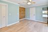 Versatile downstairs bedroom with updated flooring, ceiling fan, and built-in storage.