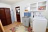 Dedicated laundry room with washer, dryer, utility sink, and built-in storage.