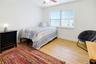 Bright downstairs bedroom with ceiling fan and spacious layout.