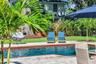 The enormous fully fenced backyard is designed for year-round enjoyment with a gas-heated saltwater sport pool, outdoor kitchen, expansive brick paved