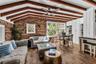 Natural light pours into the spacious family room that features warm brick walls, exposed wood beams and distinctive diamond-pane windows that create 