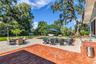 The enormous fully fenced backyard is designed for year-round enjoyment with a gas-heated saltwater sport pool, outdoor kitchen, expansive brick paved