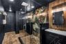 Oversized spa inspired bathroom features with dual vanities, two private water closets, a large glass-enclosed shower and elevated finishes throughout