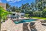 The enormous fully fenced backyard is designed for year-round enjoyment with a gas-heated saltwater sport pool, outdoor kitchen, expansive brick paved