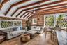 Natural light pours into the spacious family room that features warm brick walls, exposed wood beams and distinctive diamond-pane windows that create 