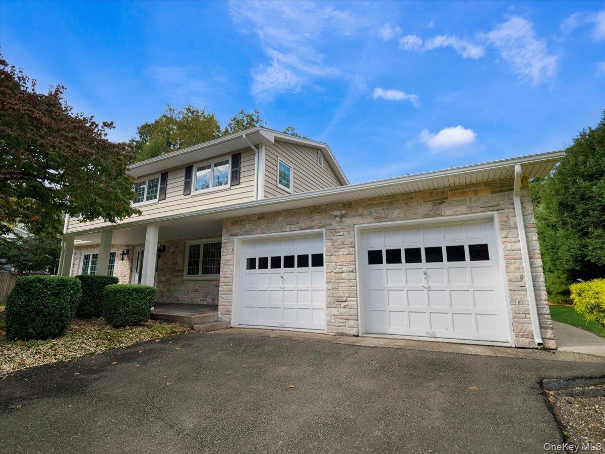 Center hall colonial with stone facade and new vinyl siding.