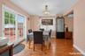 Wood-finish flooring throughout, with a crystal chandelier, and a white-framed glass sliding door leading to an outdoor deck