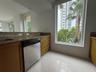 Kitchen featuring natural stone countertops, warm-toned wood cabinetry, stainless steel dishwasher, floor-to-ceiling windows, and polished tile floori