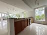 Kitchen featuring stone countertops, wood cabinetry, stainless steel dishwasher, polished tile flooring, and floor-to-ceiling windows