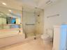 Bathroom featuring a soaking tub with a deck-mounted faucet, a frameless glass-enclosed shower, expansive wall-mounted mirror, and tile flooring