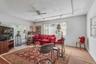 Bright living space featuring multiple windows, carpet flooring, and a ceiling fan