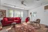 Multiple windows with vertical blinds, ceiling fan, track lighting, and wall-mounted air conditioning unit