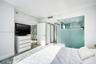 Glass-enclosed shower with frosted privacy panel, ceiling-mounted sprinkler head, and smooth-finish walls