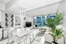 Open-concept living space featuring floor-to-ceiling windows, porcelain tile flooring, and custom modern pendant lighting