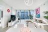 Living area featuring floor-to-ceiling windows, porcelain tile flooring, and urban skyscraper scenery